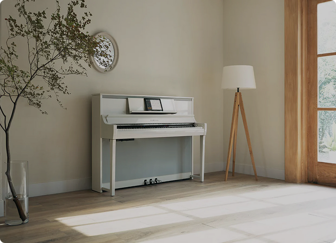 White upright digital piano in a sunlit living room, from F-Musiikki